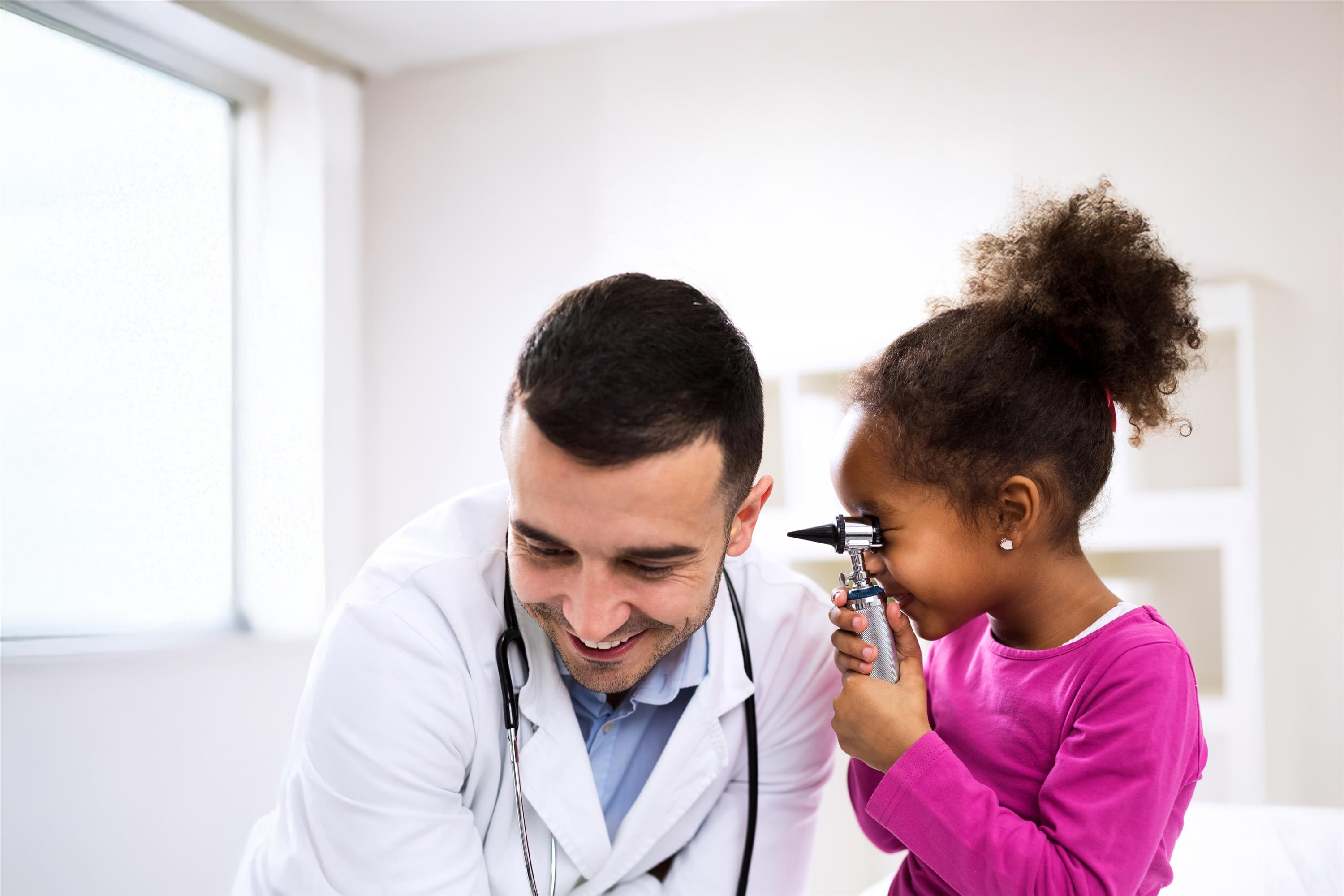 Doctor letting child use medical instrument 